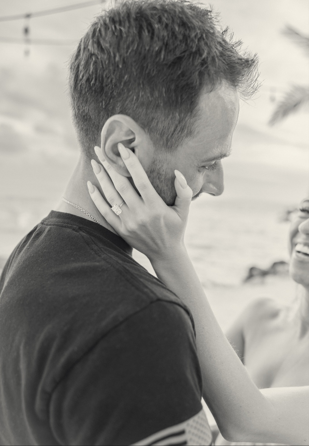 Madison holding Jonathan's face, showing her engagement ring